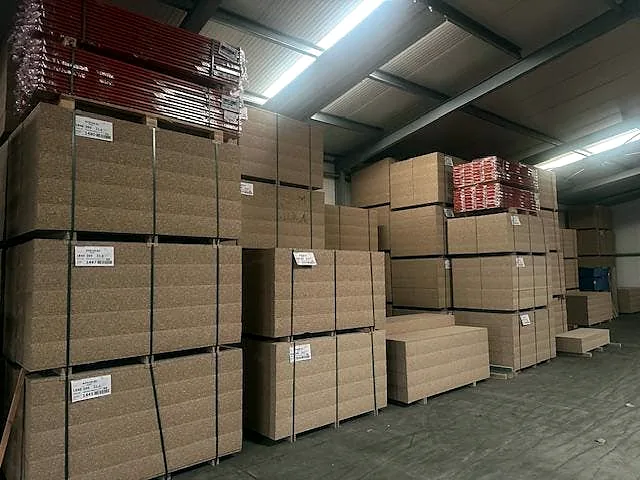 Stapels legborden in de loods van Roscom
