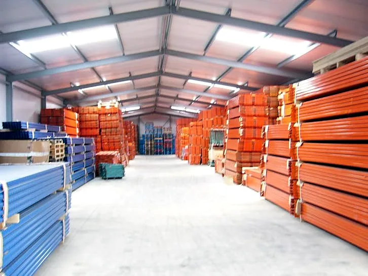 De loods van Roscom met stapels blauwe jukken en oranje liggers